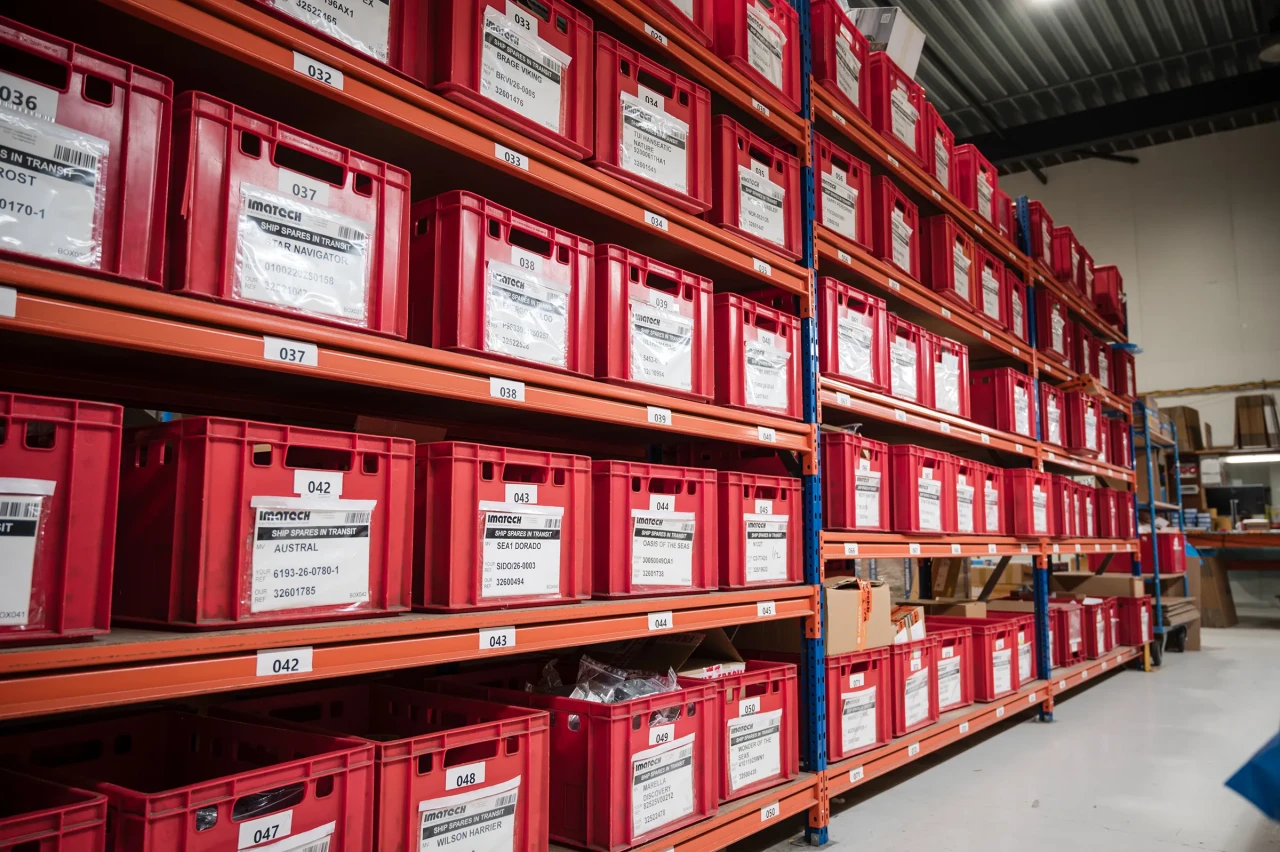 Imatech warehouse shelves filled with organized red storage bins, reflecting a comprehensive and well-structured product catalog ready for global supply.