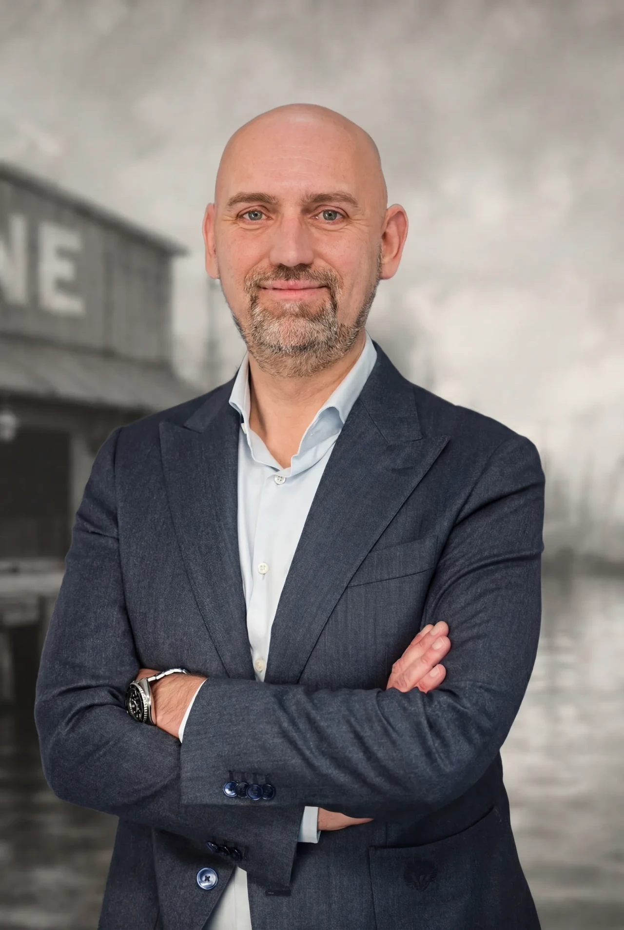 Portrait of Erling Haverkamp standing with arms crossed against a maritime-themed background.