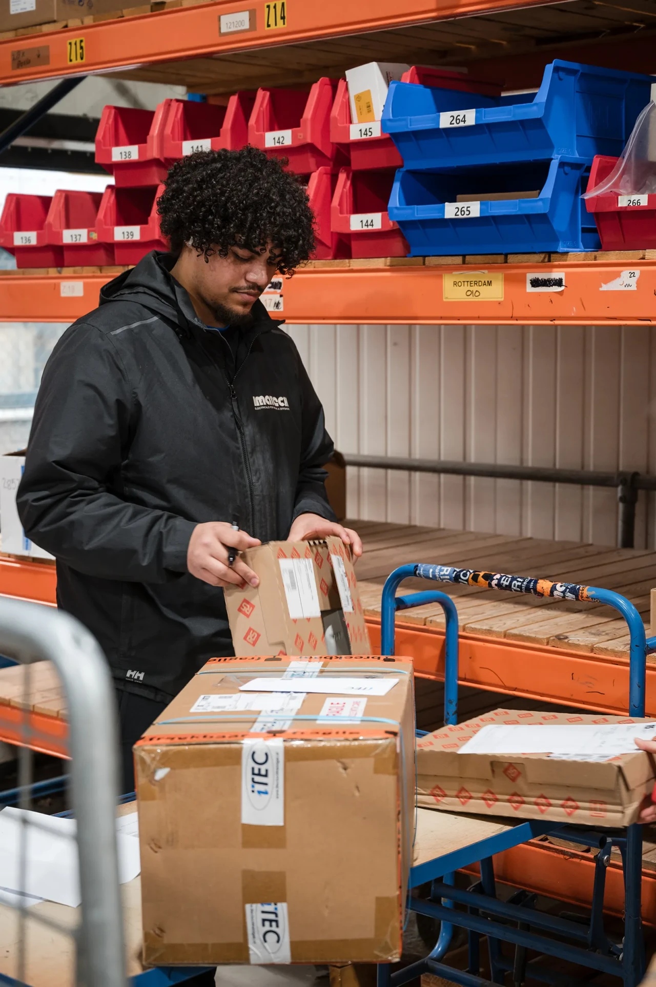 An Imatech logistics employee prepares and labels outgoing packages in the warehouse, coordinating shipments for timely global delivery.
