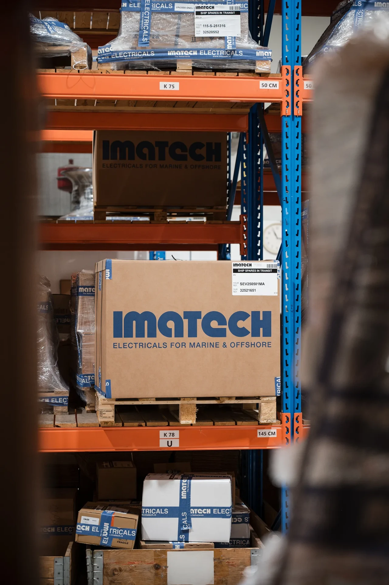 Imatech boxes are stacked on warehouse shelves, ready for shipment.